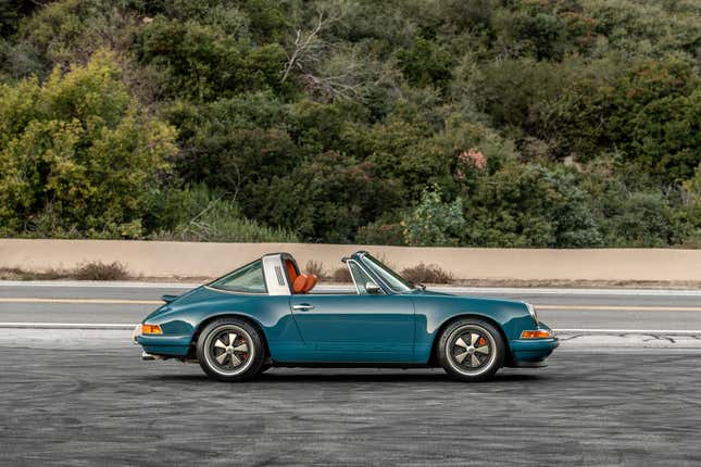 Une vue latérale de la 300e 911 de Singer, une targa 964 de 1990 dans un bleu profond avec un intérieur orange